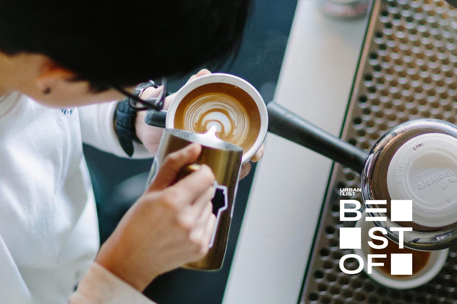 Someone makes latte art at Benedicts Cafe, one of the best spots for coffee in Auckland.